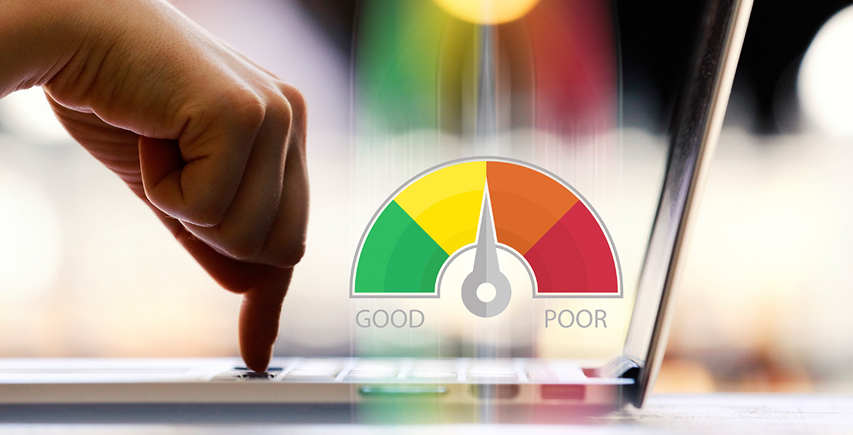 Someone pressing a key on a laptop with a graphic of a gauge with colors from green to red.