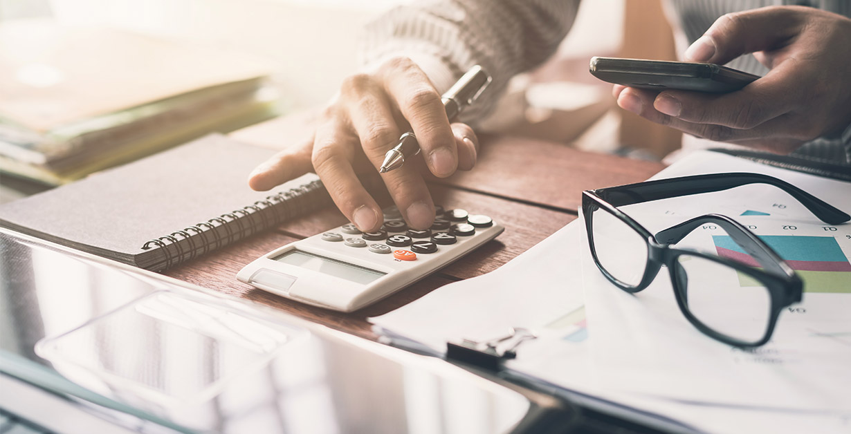 Man, at desk, reviewing his finances
